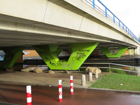 828627 Gezicht onder de Marnixbrug bij de Pompoenstraat te Utrecht, met op de lichtgroen geschilderde pijlers veel graffiti.